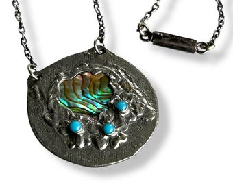 Collar colgante vintage estilo Ruskin con reminiscencias de las artes y la artesanía, con flores de nomeolvides y un hermoso abulón incrustado.