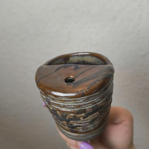 xícara de cerâmica feita à mão com furo para canudo