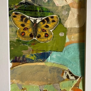 May include: A framed mixed media collage featuring a yellow butterfly with black and orange spots positioned above a painted badger. The background consists of layered abstract shapes in shades of green, blue, beige, and white with visible brushstrokes.