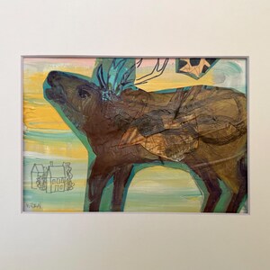 May include: A mixed media artwork featuring a brown moose silhouette layered over a yellow and blue painted background. A small line drawing of a house is visible in the lower left corner, and the artist signature WREN is printed below it.