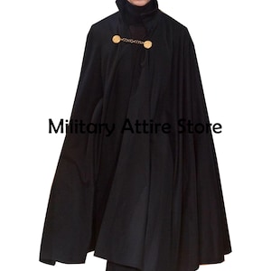 May include: A black cape featuring a high collar and a gold-toned metal chain clasp at the neckline. The garment has a full, flowing silhouette and is displayed with the text Military Attire Store overlaid on the center of the fabric.