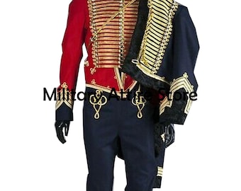 May include: A red military-style jacket with gold braided trim and buttons, paired with dark blue trousers. A matching dark blue cape with gold trim and black fur lining is draped over one shoulder. The text Military Attire Store is visible.