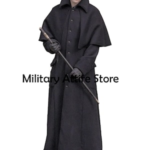 May include: A long black overcoat featuring a structured collar, a button-down front, and an attached shoulder cape. The garment is paired with dark gloves and a long walking stick. The text Military Attire Store is visible in the center.
