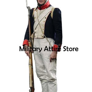 Puede incluir: Un uniforme militar histórico que presenta una chaqueta azul oscuro con puños rojos y un chaleco blanco con botones dorados. El conjunto incluye pantalones blancos, una bandolera blanca y un mosquete largo de madera. El texto Military Attire Store es visible.