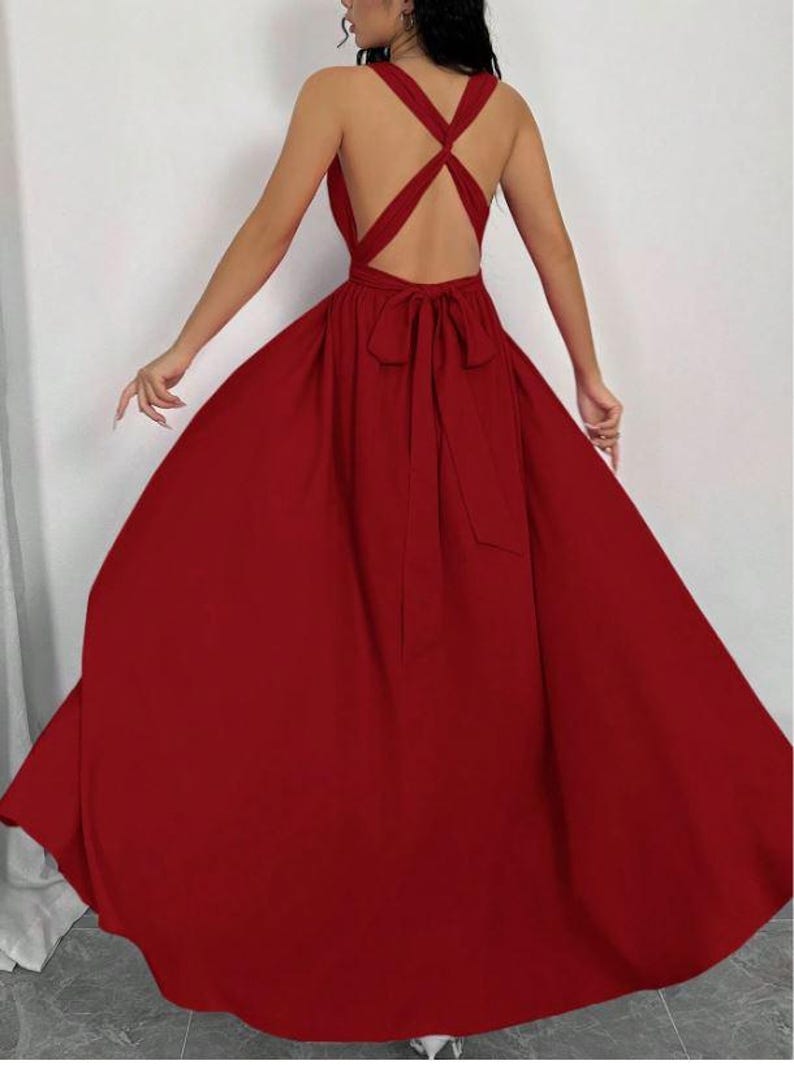 Pu&ograve; includere: Un abito lungo color rosso cremisi con schiena incrociata e fiocco in vita. L'abito presenta una gonna fluida e uno scollo all'americana. Il design senza schienale aggiunge un tocco di eleganza a questo abito da sera.