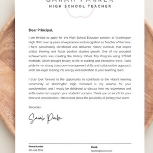 May include: A resume template with the name "Sarah Parker" and the title "High School Teacher" at the top. The resume is on a white background with text and a signature. The resume is on a wooden tray.