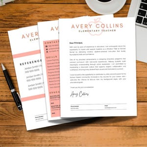 May include: A resume and reference documents are displayed on a wooden desk. The resume is titled "Avery Collins Elementary Teacher" with a pink apple logo. A black pen and a laptop are also visible.