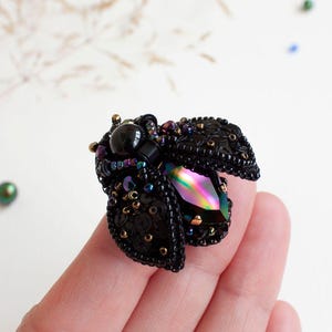Unique beadwork beetle brooch featuring dark rainbow crystal