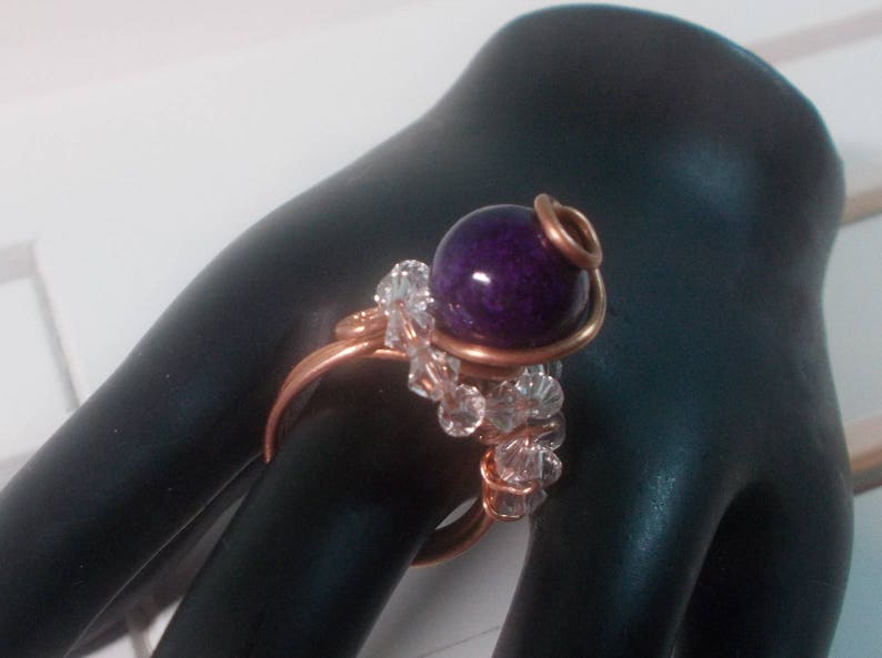 May include: A copper wire ring featuring a purple gemstone and clear crystal beads.