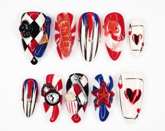 May include: A set of ten artificial nails with a variety of designs. The nails feature red, white, blue, and black colors, with patterns like stripes, diamonds, and playing card motifs. Some nails have 3D embellishments.