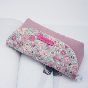 May include: A pink and floral patterned fabric eyeglass case with a pink leather tag that says "Hand Made".