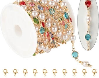 May include: A spool of gold-colored chain with alternating white faux pearls and colorful gemstones. The chain is accented with gold-colored jump rings and lobster clasps, perfect for jewelry making.