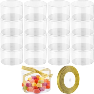 May include: Clear, cylindrical plastic containers stacked in rows. One container is filled with colourful sweets and tied with a gold ribbon. A roll of gold ribbon is also visible. These containers are suitable for party favours or small gifts.