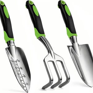Op de afbeelding: Een set van drie tuingereedschappen met zwarte handvatten en groene accenten. De gereedschappen omvatten een troffel met een liniaal aan de zijkant, een handhark en een kleine handschep.