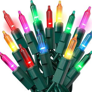 Pode incluir: Um close-up de uma sequência de luzes de Natal coloridas. As luzes são uma mistura de vermelho, verde, azul, amarelo e rosa. As lâmpadas são pequenas e redondas, com bases verdes. Os fios são verdes.