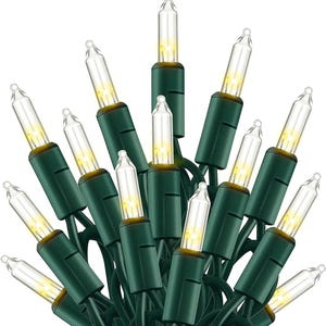 May include: A cluster of clear mini Christmas lights with a warm white glow. The bulbs are encased in clear glass and set on green wire. The lights are ideal for holiday decorating.