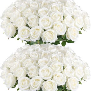 May include: Two bouquets of white roses with green foliage. The roses are fully open, displaying numerous petals in a layered arrangement. The image is well-lit, emphasising the delicate texture of the flowers.