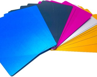 Puede incluir: Un abanico de láminas metálicas de colores en azul, azul oscuro, rosa, plata y oro. Las láminas están dispuestas en forma de abanico, con la lámina azul en la parte delantera.