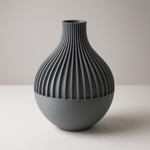 May include: A gray ceramic vase with a ribbed design. The vase has a rounded bottom and a narrow neck.