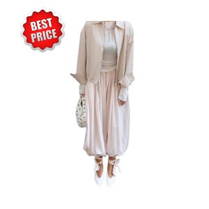 May include: A light beige outfit consisting of a long-sleeved jacket, a top, and balloon pants. The outfit is paired with white ballet flats with ribbon ties and a white handbag. A red and white "BEST PRICE" sticker is in the upper left corner.