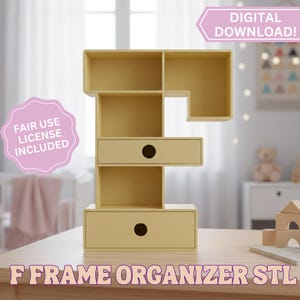 Puede incluir: Un organizador amarillo en forma de F con dos cajones y múltiples espacios de almacenamiento. El texto "F FRAME ORGANIZER STL" está en la parte inferior. La imagen también incluye el texto "¡DESCARGA DIGITAL!" y "LICENCIA DE USO JUSTO INCLUIDA".