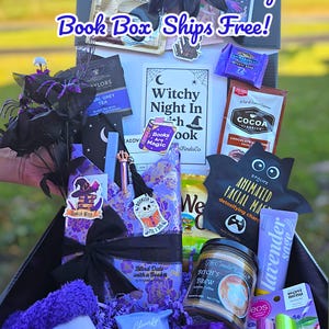 May include: A witch-themed gift box filled with various items. The box includes a candle, facial mask, tea, chocolate, socks, and other treats. The box is decorated with purple and black accents and the text "Limited Edition! Witchy Book Box Ships Free!"