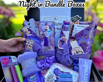 May include: A gift basket filled with purple-themed items, including books, socks, lip balm, and chocolate. The box is decorated with floral patterns and the text "Two Books in a Series Girls Night in Bundle Boxes".