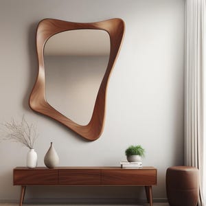 May include: A wooden console table with three drawers, a brown leather ottoman, and a large, abstract, wooden framed mirror on a white wall.  The console table has a light wood finish and the ottoman is round.