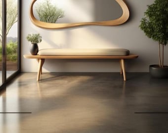 May include: A minimalist interior scene featuring a wooden bench with a light-colored cushion, a curved wooden mirror, and a potted plant. The room has a polished concrete floor and a large window with a view of greenery.