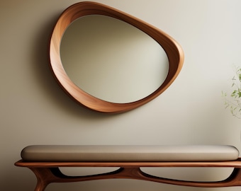May include: A contemporary, oval wooden mirror with a natural wood grain finish is mounted above a bench. The bench features a brown cushion and a matching wooden frame with a distinctive, curved design. The wall is a neutral beige colour.