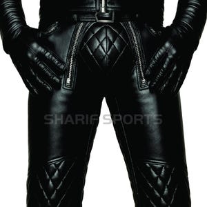 Op de afbeelding: Zwarte leren broek met gewatteerde ruitpatroon details en ritszakken. De broek maakt deel uit van een leren outfit, met bijpassende handschoenen en een jas. De tekst "SHARIF SPORTS" is zichtbaar.