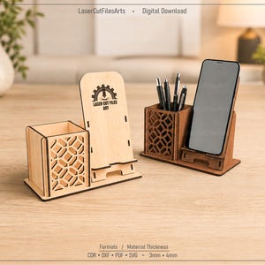 Könnte beinhalten: Zwei lasergeschnittene Schreibtisch-Organizer aus Holz mit einem Stiftehalter in geometrischem Gittermuster und einem integrierten Smartphone-Ständer. Ein Organizer ist aus hellem Holz, der andere aus dunklem. Das helle Holz zeigt den Text Laser Cut Files Art.