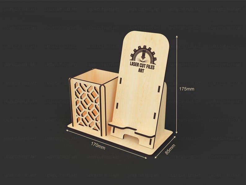May include: A light-colored wooden desk organizer featuring a square pen holder with a geometric cutout pattern and an integrated phone stand. The stand displays the text LASER CUT FILES ART. Dimensions are 170mm wide, 85mm deep, and 175mm high.