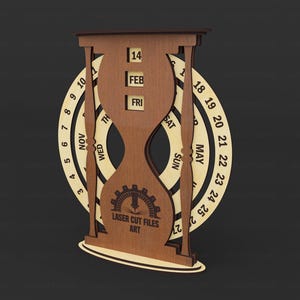 May include: A wooden perpetual calendar in the shape of an hourglass. The calendar displays the date, month, and day. The outer ring shows the months and days of the month. The text "LASER CUT FILES ART" is visible.