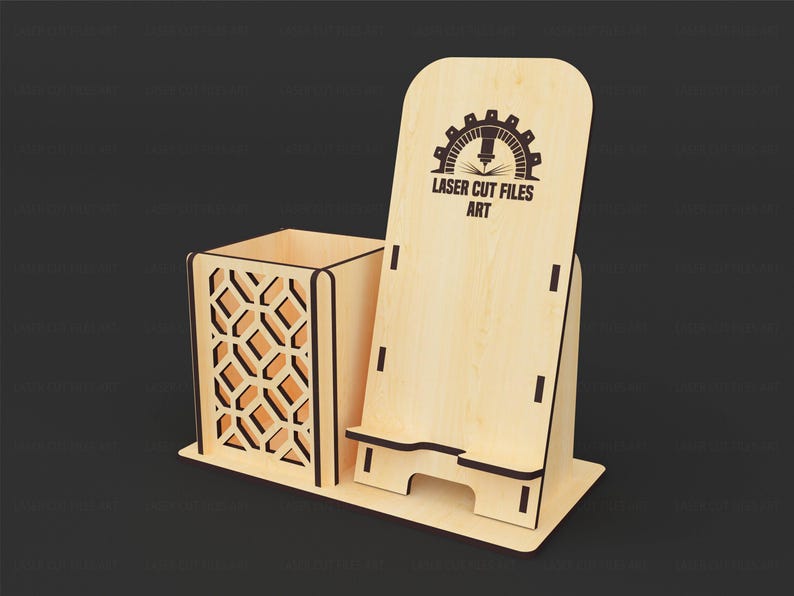May include: A light-colored wooden desk organizer featuring a square pen holder with a geometric lattice cutout pattern and an integrated upright mobile phone stand. The phone stand displays the black text LASER CUT FILES ART with a gear icon.