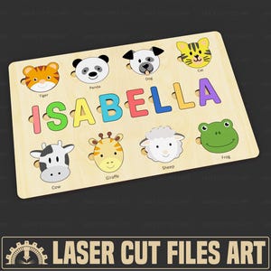 May include: Wooden puzzle with the name "ISABELLA" in colourful, removable letters. The puzzle features animal faces including a tiger, panda, dog, cat, cow, giraffe, sheep, and frog. The puzzle is made of light-coloured wood.