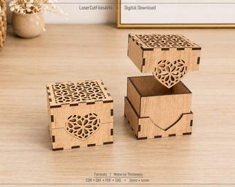 May include: Two light brown wooden boxes with laser-cut heart patterns on the sides and lids. One box is closed, and the other has its lid lifted. The text LaserCutFilesArts, Digital Download, Formats, and Material Thickness 3mm 4mm is visible.