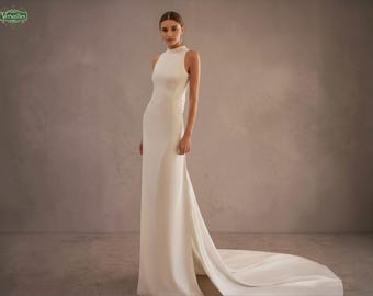Vestido de novia moderno de crepé con cuello alto, espalda abierta, sencillo, con cola capilla, minimalista, con botones en la espalda.