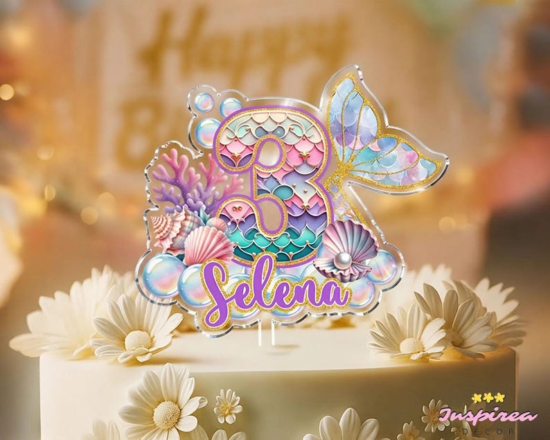 Puede incluir: Un adorno para tarta con tem&aacute;tica de sirena. Presenta el n&uacute;mero 3, una cola de sirena, conchas marinas y el nombre "Selena" en escritura p&uacute;rpura. El dise&ntilde;o incorpora colores pastel y detalles dorados, ideal para una celebraci&oacute;n de cumplea&ntilde;os.