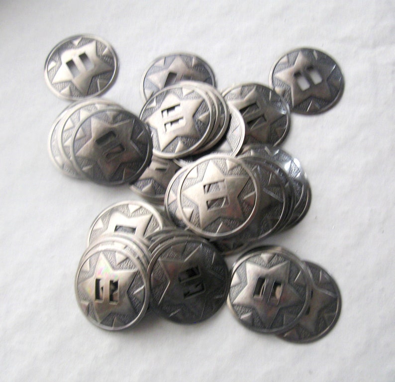 May include: A pile of silver-toned metal buttons with a star and the number "II" embossed on each button.