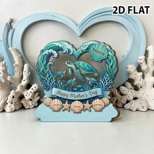 Pode incluir: Decoração de madeira para o Dia das Mães com uma família de tartarugas marinhas dentro de uma moldura em forma de coração. O design inclui ondas do oceano, corais e o texto "Happy Mother's Day". Os nomes estão inscritos em conchas.