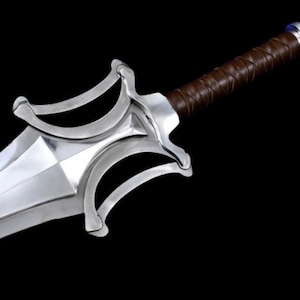May include: A silver-colored sword with a brown leather-wrapped handle. The blade is wide and angular, with a decorative guard featuring curved elements. The sword is set against a black background, highlighting its metallic sheen.