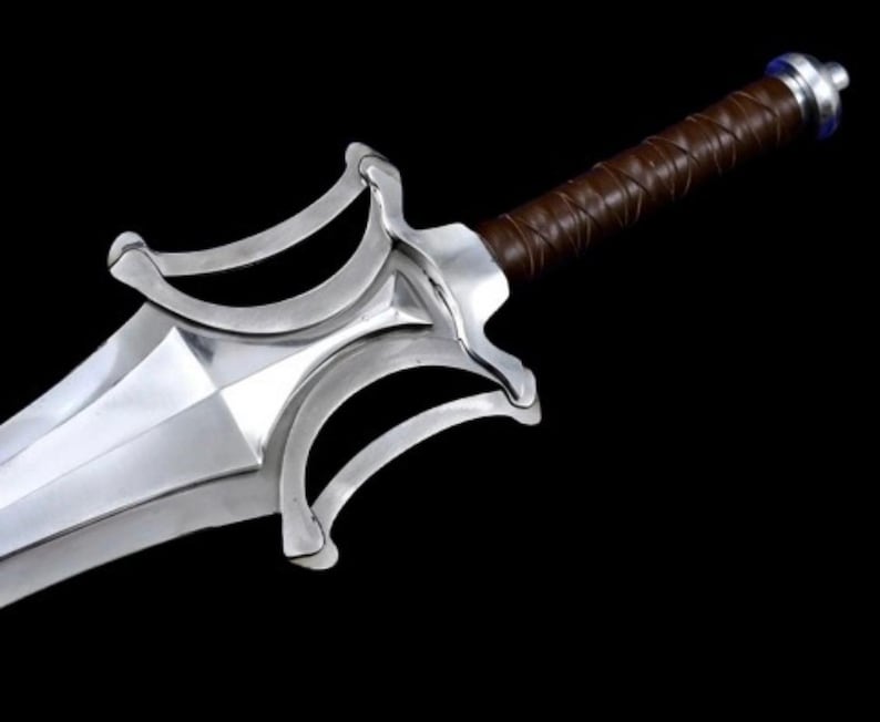 May include: A silver-colored sword with a brown leather-wrapped handle. The blade is wide and angular, with a decorative guard featuring curved elements. The sword is set against a black background, highlighting its metallic sheen.