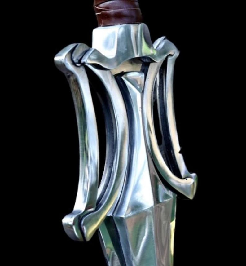 May include: Close-up of a silver sword hilt with a brown leather-wrapped handle. The hilt features a decorative, symmetrical design with curved, polished metal elements. The blade is not visible. The background is black.