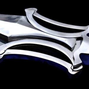 May include: Close-up of a polished silver sword with a wide blade and ornate, curved handguard. The handguard features a series of parallel black lines. The sword's handle is a dark brown color. The background is black.