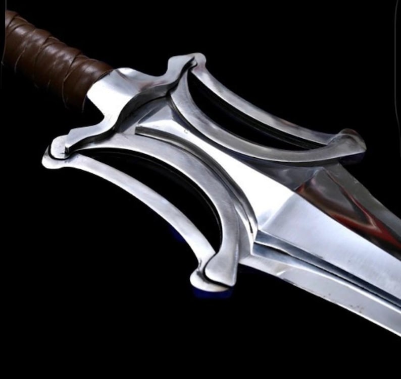 May include: A close-up of a silver sword with a brown leather-wrapped handle. The blade is polished and reflective, with a distinctive curved design on the hilt. The sword is set against a black background.