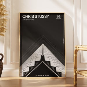 Puede incluir: Una impresión artística en blanco y negro enmarcada con el texto "CHRIS STUSSY - ALL NIGHT LONG". La obra de arte representa un diseño arquitectónico geométrico. La impresión se exhibe en una habitación con un jarrón de plantas secas y una silla de bambú.