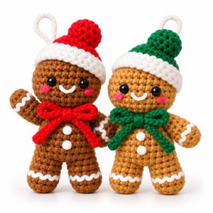 May include: Two crocheted gingerbread ornaments with black eyes, pink cheeks, and white icing details. One wears a red hat and bow, the other a green hat and bow. Both have white hanging loops on top and two white buttons on their chests.