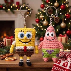 May include: Two crochet keychains featuring SpongeBob SquarePants and Patrick Star. The yellow rectangular SpongeBob has blue eyes and brown pants, while the pink star-shaped Patrick has green shorts with purple flower patterns.