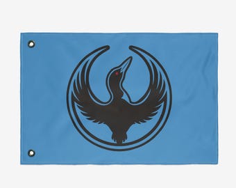 May include: A light blue flag featuring a black bird emblem within a circular frame. The bird has outstretched wings and a red eye. The flag has two grommets for hanging.